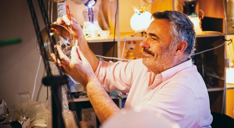 L’artiste au milieu des lustres et de ses propres créations dans son atelier de Puidoux. MISSON-TILLE